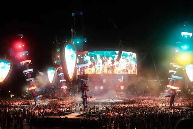 Palco illuminato e pubblico a un concerto all’aperto