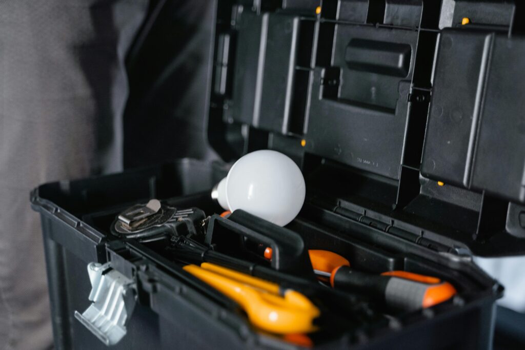 Open toolbox containing various tools and a light bulb.