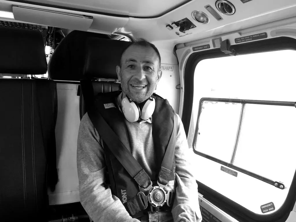 Tecnico in elicottero con cuffie e giubbotto di salvataggio